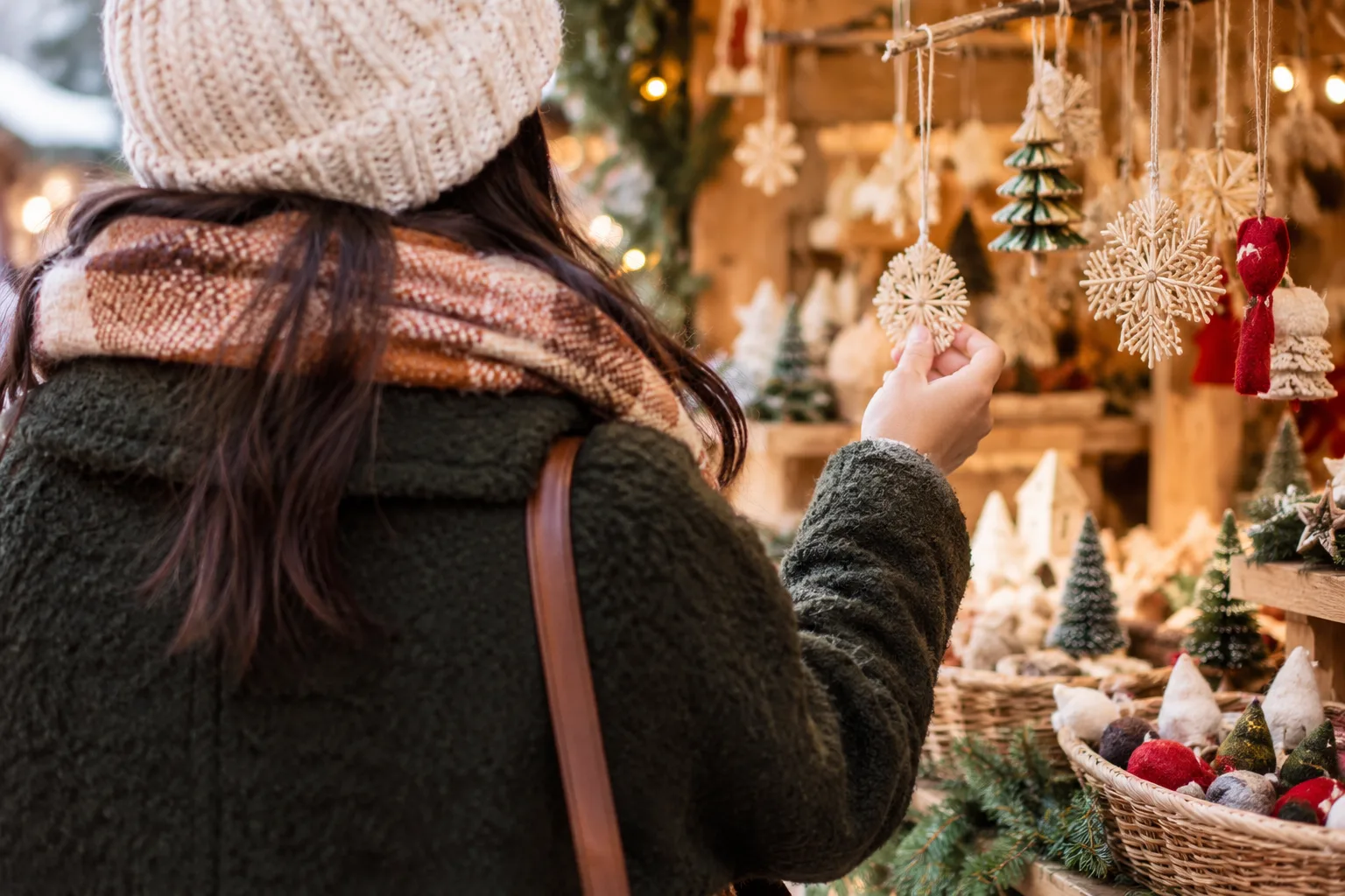 Shoppers browse handmade gifts, holiday decorations, and food stalls at a festive winter craft market.